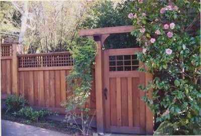 a wooden gate surrounded by greenery and flowers