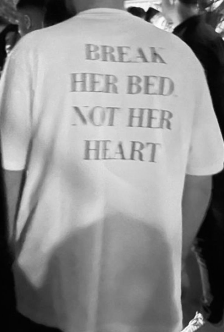 a man wearing a white shirt that says break her bed not her heart