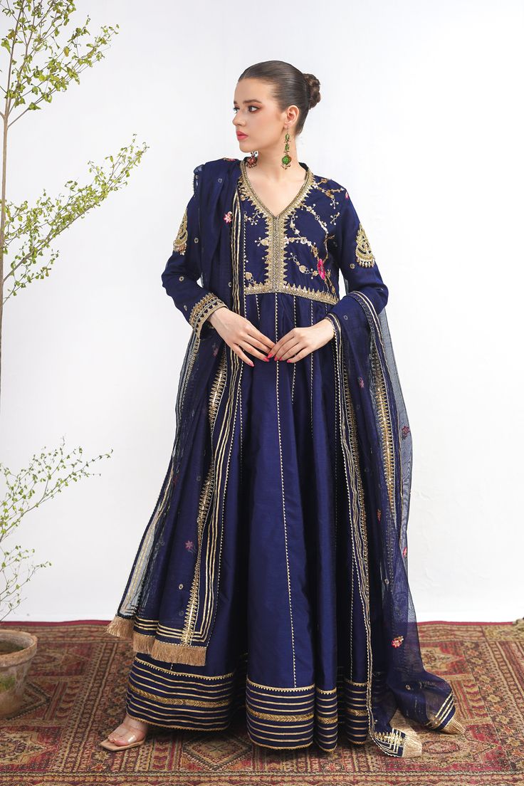 A royal blue frock in raw silk with embroidery on the bodice and a matching net dupatta with kiran along its width. Finished with a jamawar trouser for a regal touch.3-piece suitReady to wear Semi-stitched Cotton Silk Blue Anarkali Set, Blue Slub Silk Churidar For Wedding, Anarkali Cotton Silk Dress With Sheer Dupatta, Blue Cotton Silk Churidar With Dabka Work, Blue Dresses With Resham Embroidery In Cotton Silk, Traditional Blue Slub Silk Salwar Kameez, Floor-length Cotton Silk Salwar Kameez With Dabka Work, Blue Cotton Silk Churidar With Traditional Drape, Embroidered Slub Silk Anarkali Dress