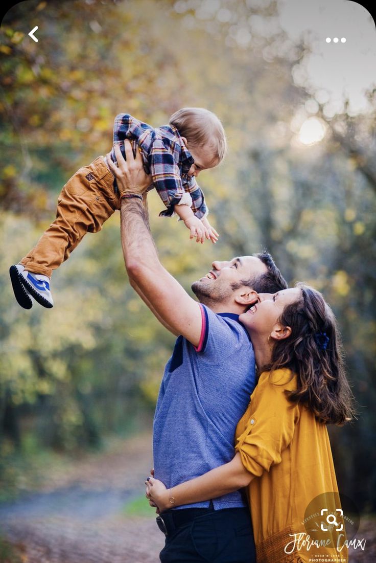 a man holding a baby up in the air