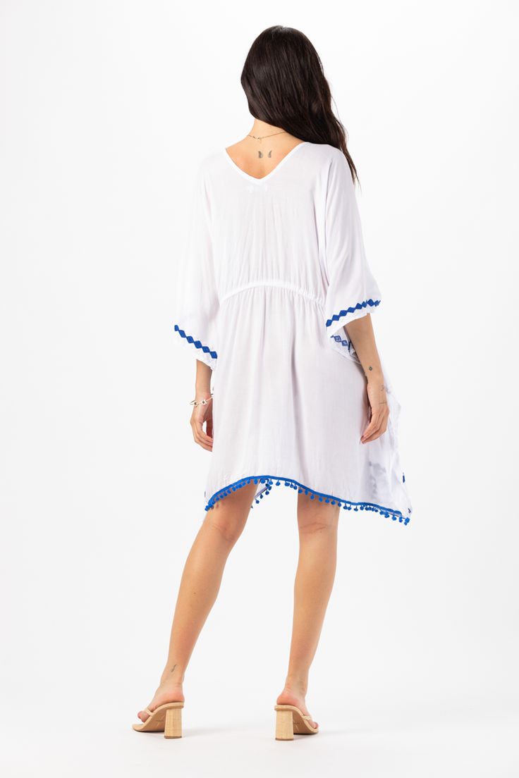 Elevate your beach wardrobe with our Mykonos Mini Dress. This exquisite embroidered coverup allows you to embrace the artistry of seaside fashion. With its intricate detailing and effortless charm, this coverup is sure to make you feel like a beach goddess wherever your adventures take you. Details: 100% Rayon Hand Wash in Cold Water and Lay Flat to Dry Features: Unlined, V-neckline, Embroidered detail, Tassel tie closure to cinch waist for an adjustable fit, Sides drape lower, Billowing short s Blue Boho Dress For Beach Cover-up, V-neck Beach Dress For Beach Wedding, Beachwear V-neck Cover-up With Tassels, Summer V-neck Tassel Cover-up, Summer V-neck Cover-up With Tassels, Embroidered V-neck Boho Dress For Vacation, Vacation V-neck Kaftan With Tassel Ties, Beach Season Embroidered Cover-up, Breezy Tunic Cover-up For Vacation