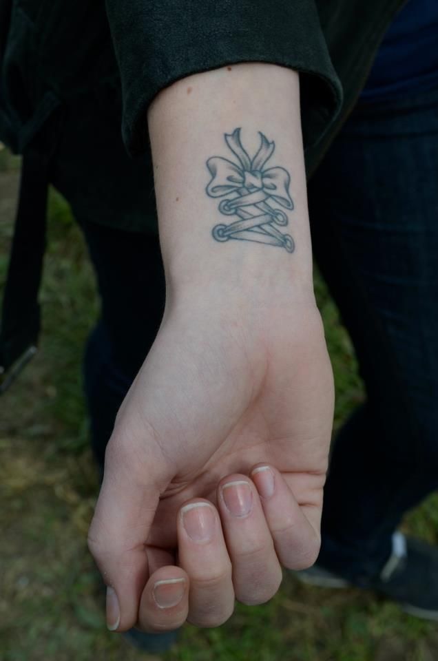 a person with a tattoo on their wrist holding the hand of another person's arm