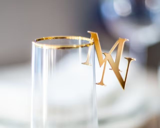 two gold letters are placed on top of each other in a clear glass tube with the letter v inside it