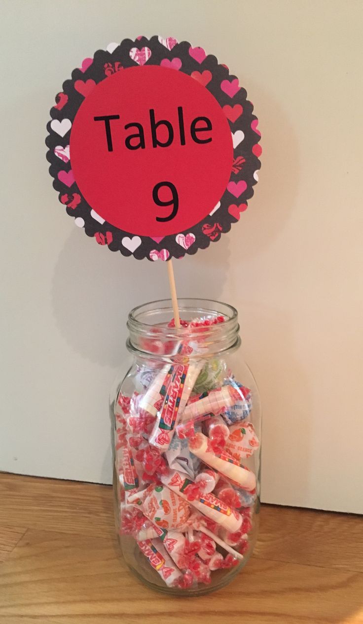 a jar filled with candy sitting on top of a wooden table