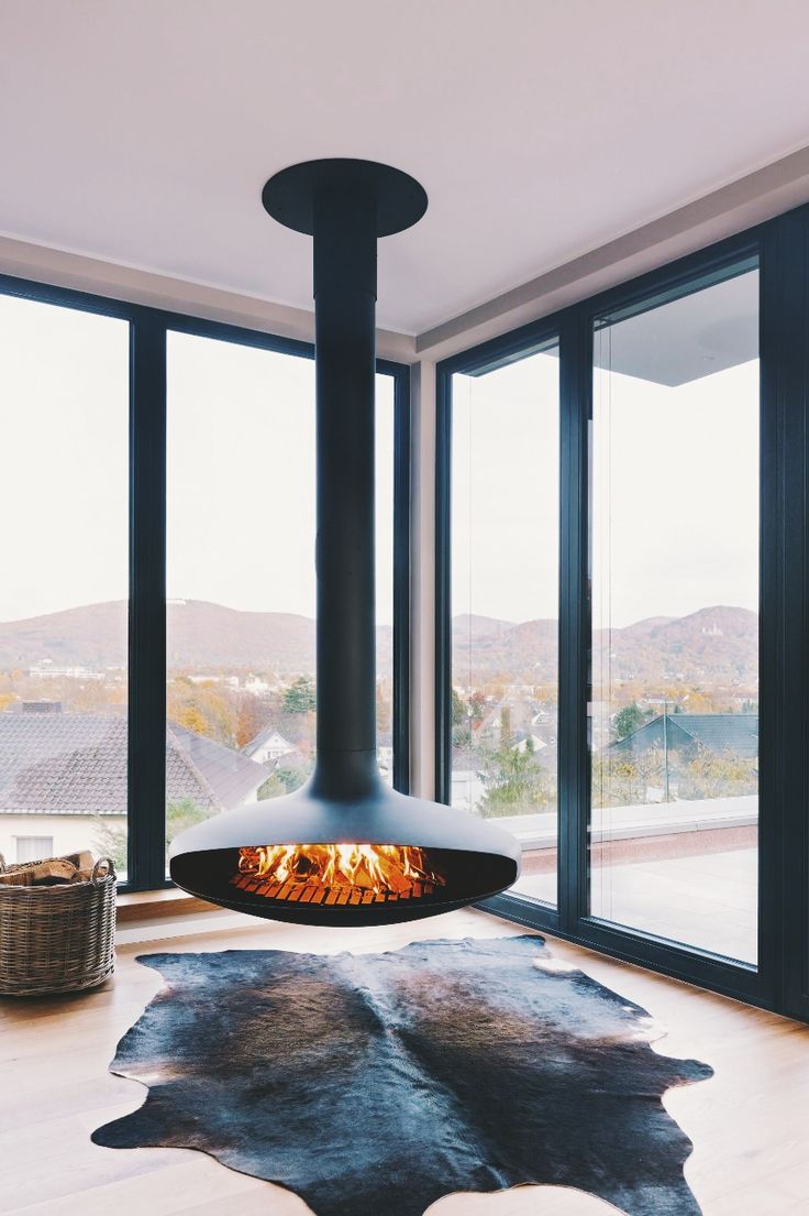 a living room filled with furniture and a fire place in the middle of it's floor