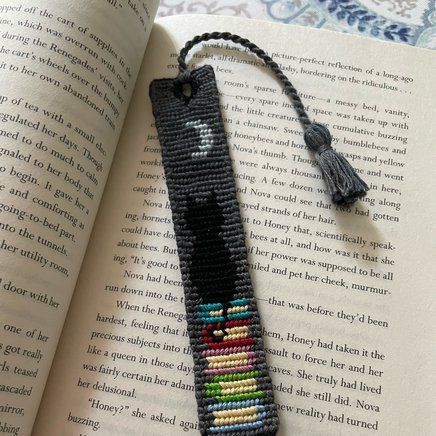 a bookmark made out of beads with an image of a black cat on it