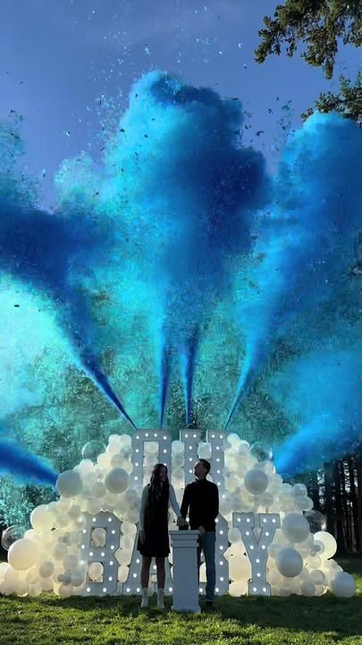 two people standing in front of a large blue cloud