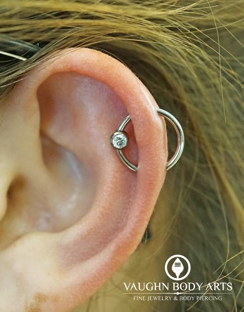 a woman's ear is shown with a single diamond in the middle of it