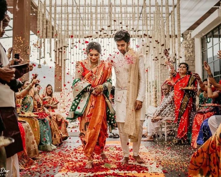 the bride and groom are walking down the aisle with confetti thrown all over them