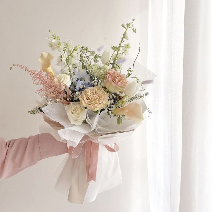 a woman holding a bouquet of flowers in her hand