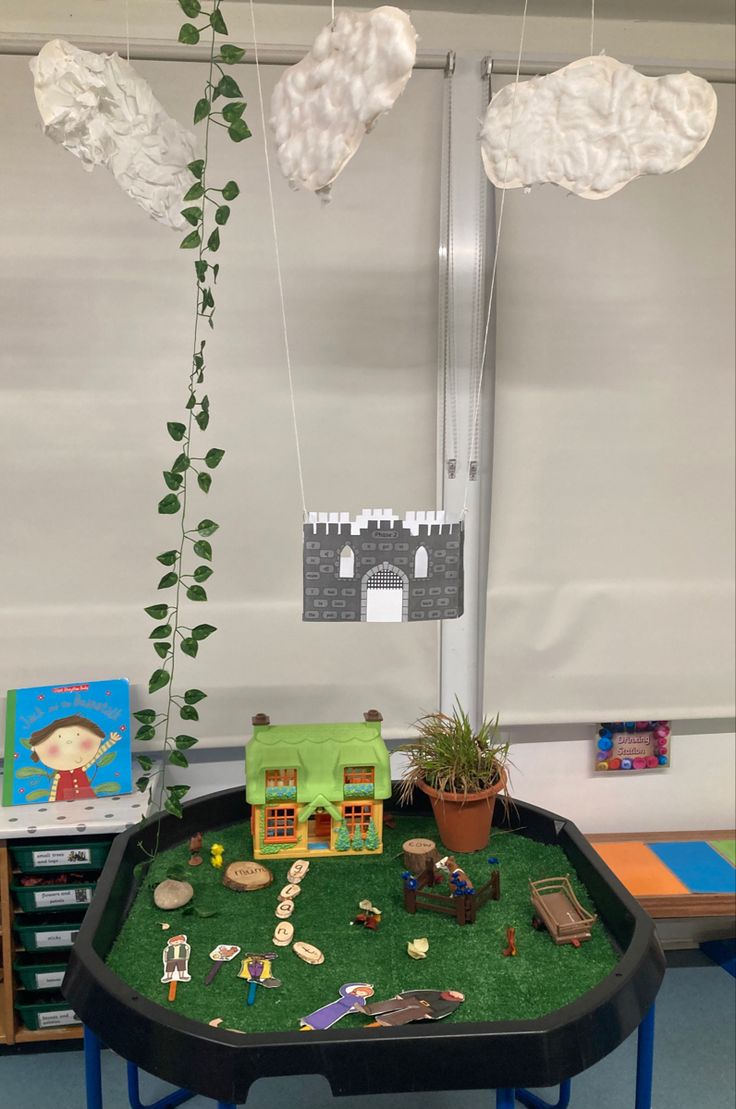 a table with some toys on top of it and a plant growing out of the middle