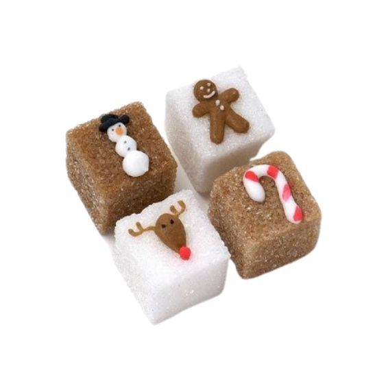 four small pieces of food with christmas decorations on them, including marshmallows and sugar cubes