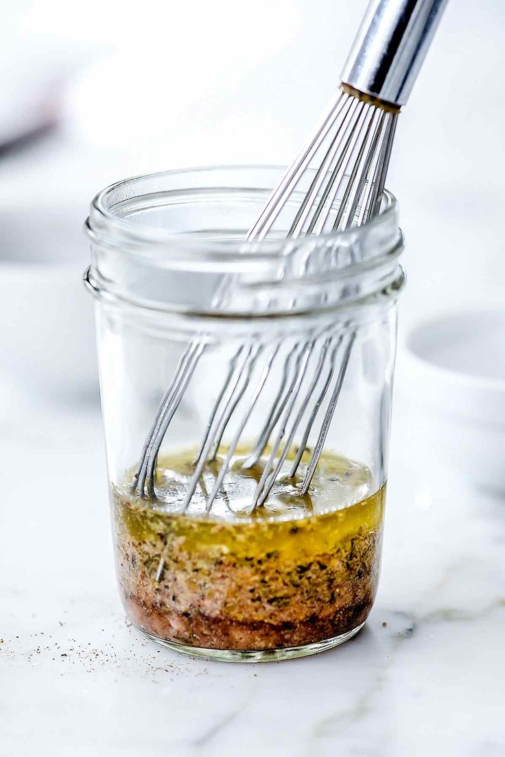 a whisk is being used to mix ingredients in a jar