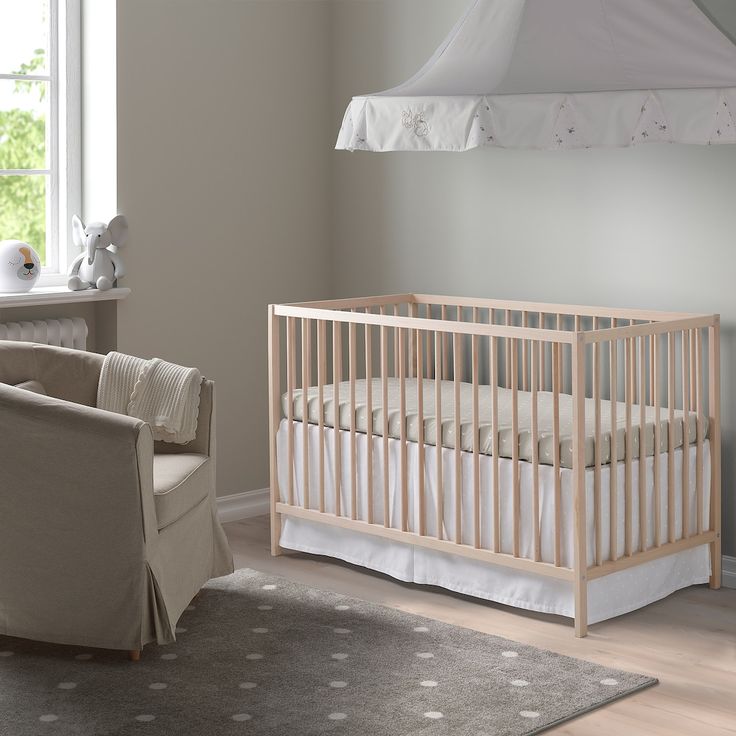 a baby's room with a chair, crib and bed in it is shown