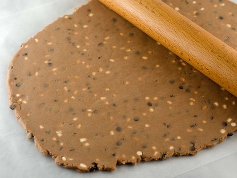 a cookie with chocolate frosting and a wooden spoon on top, sitting on wax paper