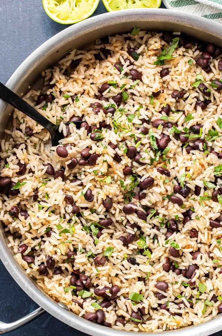 a pot filled with rice, beans and cilantro on top of a table