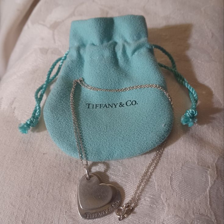 This Is A Retired But Classic Tiffany & Co. Double Heart Necklace. The Pendant Has A Double Heart With Tiffany & Co. On The Front Of The Large Heart And Tiffany & Co. 925 On The Back. The Smaller Heart Has No Markings. The Chain Is A 16" Thin Rolo Link With A Spring Ring Clasp. The Chain Has A Bar Stamped Tiffany & Co On One Side And Ag 925 On The Other. This Piece Comes With Tiffany Pouch As Pictured. This Is In Very Good Pre-Owned Condition. There Is Light Scratching On Both Hearts. Jewelry Tiffany, Double Heart Necklace, Large Heart, Tiffany Co Jewelry, Double Heart, Small Heart, Necklace Sterling Silver, A Bar, Spring Rings