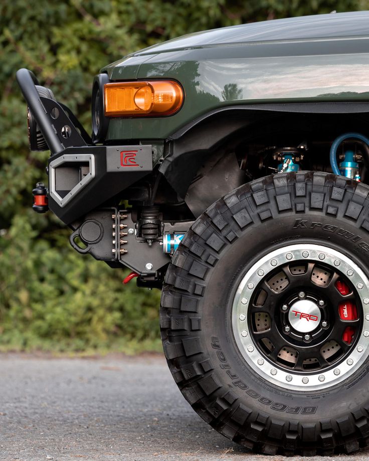 an off - road vehicle is parked on the side of the road in front of some bushes