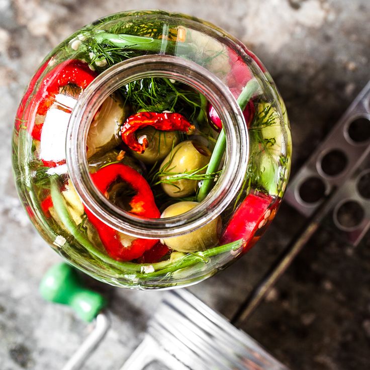 a jar filled with vegetables sitting on top of a table