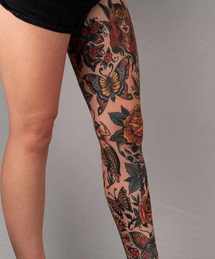 a woman's legs with tattoos and flowers on them, both showing their thighs