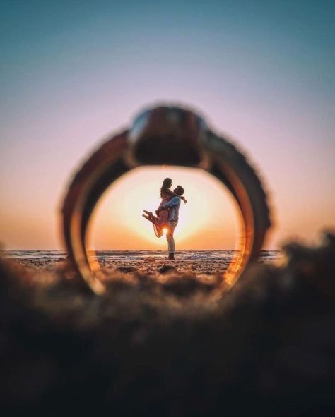 a person standing on the beach in front of an object that looks like a ring