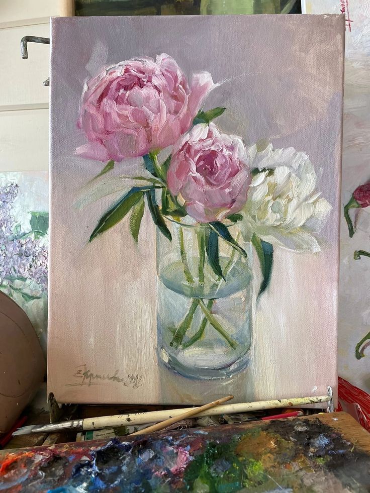 a painting of pink flowers in a glass vase on a table with paintbrushes