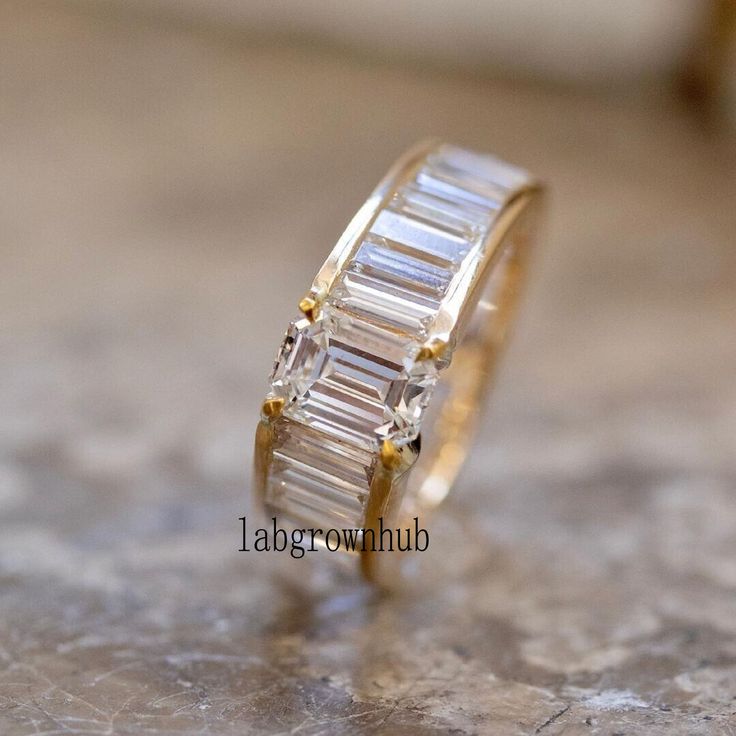 a gold ring with three baguettes on it sitting on top of a table