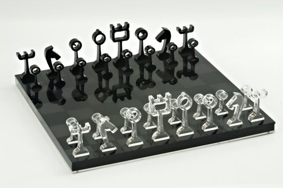 a chess board with black and white figures on it's back side, all in different shapes and sizes