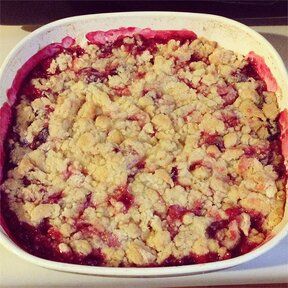 a white dish filled with crumbled food on top of a counter next to a stove