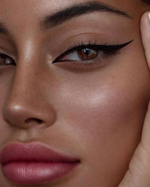 a close up of a woman's face with eyeliners on her eyes