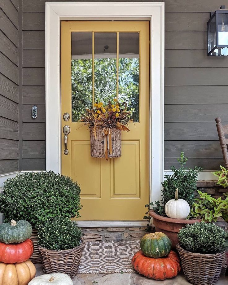 the front door is decorated with pumpkins and gourds