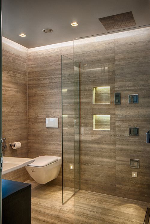 a bathroom with a glass shower door next to a toilet