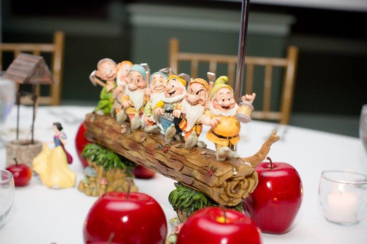 a group of figurines sitting on top of a wooden sled filled with apples