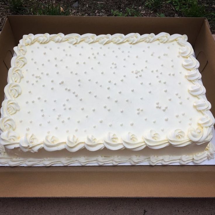 a large white frosted cake in a box