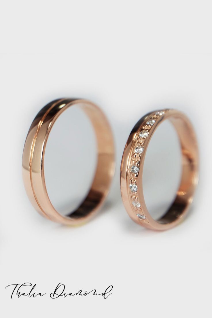 two rose gold wedding rings with white diamonds on the inside, set against a plain background