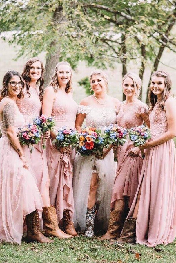 a group of women standing next to each other in front of trees with flowers on them