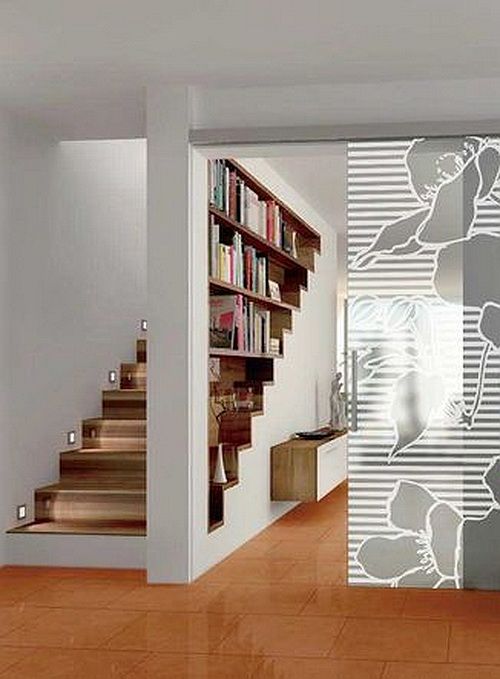 an open door with flowers painted on it in a living room next to stairs and bookshelves