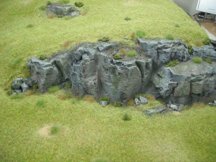 an artificial rock formation is shown in the grass