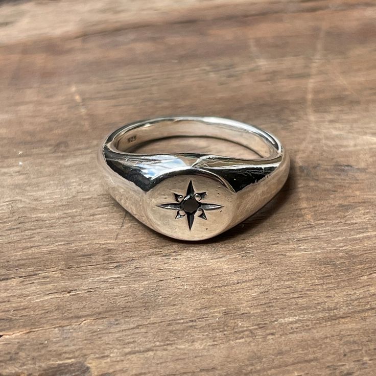 A classic small circle signet ring star-set with a 2mm black diamond. These timeless signet rings are meticulously crafted by hand in our Melbourne workshop, created out of wax and then cast into solid precious metal. Made with the highest quality Australian sterling silver to last forever. Made solid, not hollow like many others, all of our rings are hand-stamped with a Sterling Silver (925) hallmark and Custom Creed makers mark and come gift-wrapped in a branded box with satin black ribbon. Du Mens Rings Signet, Signet Rings Men, Minimalist Star Shaped Signet Ring As Gift, Silver Signet Ring With Single Diamond For Promise, Oval Silver Signet Ring For Promise, Anniversary Sterling Silver Signet Ring With Diamond, Silver Signet Ring With Single Diamond As Gift, Celestial Star Shaped Signet Promise Ring, Classic Silver Star Shaped Rings