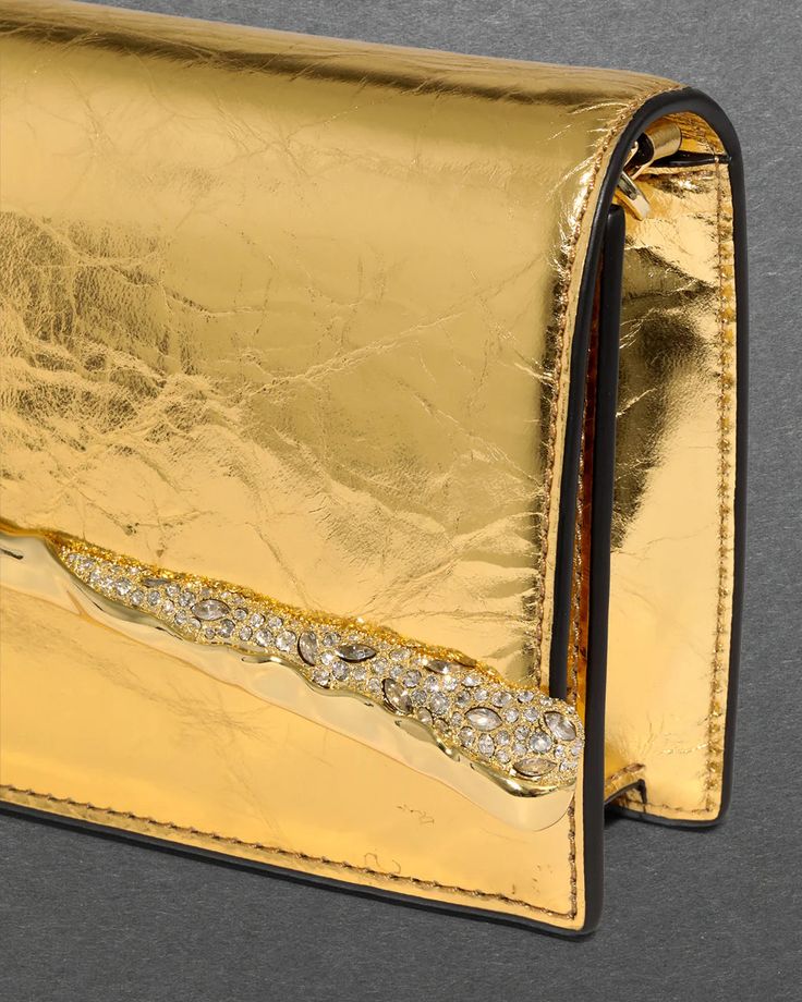 Introducing the latest must-have from Alexis Bittar, the Gold Angular Convertible Crossbody Bag. Crafted with a sliver of molten 14k gold-plated metalwork accentuated with custom-cut Austrian crystals, this bag exudes elegance and sophistication. The sculptural hardware beautifully complements the crinkled Italian leather, finished with a cracked metallic foil. Plus, with its detachable snake chain, this versatile bag can easily be converted from a crossbody to a clutch, making it the perfect ac Glamorous Gold Rectangular Bag, Modern Gold Shoulder Bag With Turn-lock Closure, Chic Gold Shoulder Bag With Turn-lock Closure, Gold-tone Hardware Clutch Shoulder Bag For Shopping, Gold-tone Hardware Crossbody Clutch, Convertible Crossbody Bag, Evening Jewelry, Ring Sale, Alexis Bittar