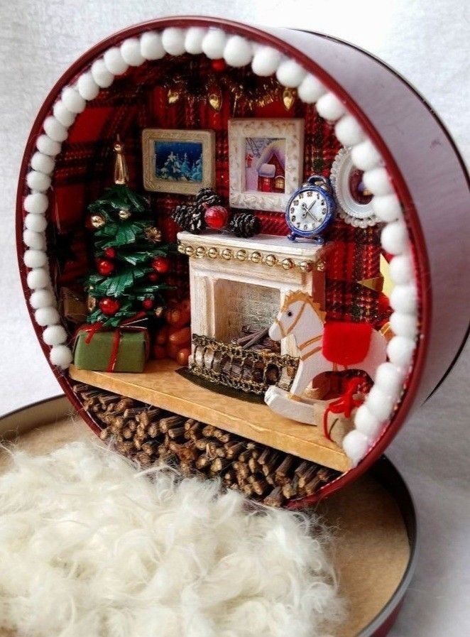 a miniature christmas scene in a red and white plate with fur on the floor next to a fireplace