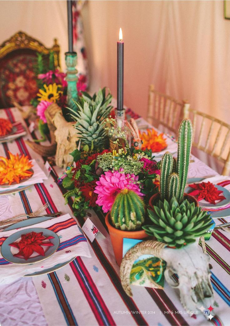 the table is set with colorful flowers and succulents