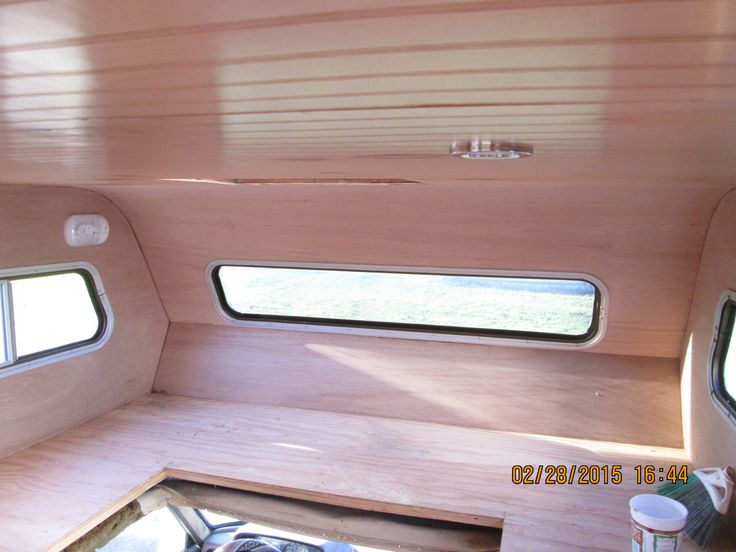 the inside of a small camper with two windows