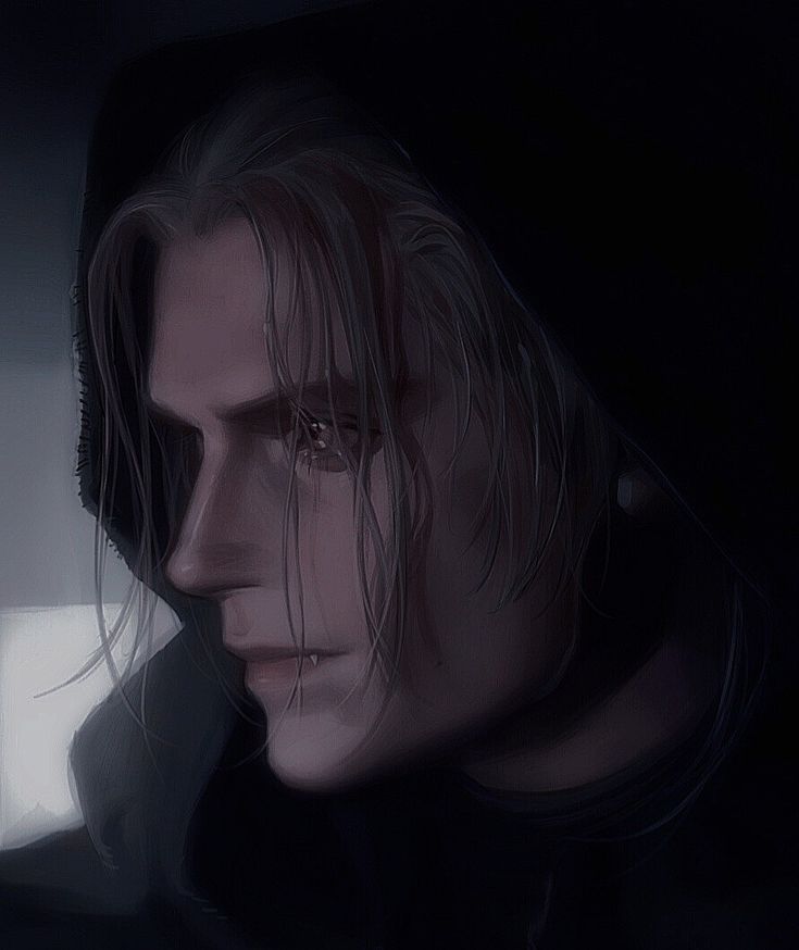 a man with long hair wearing a black hoodie and looking off into the distance