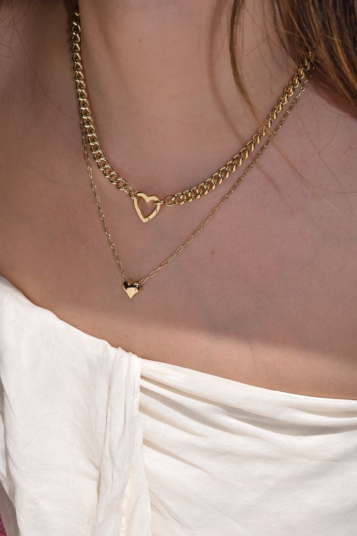 Meet Tia—your new favorite statement piece. With a chunky chain and adorable heart-shaped clasp, this necklace is perfect for adding your favorite charms. It’s the kind of piece that effortlessly adds a fun, stylish twist to any look. Heart clasp chain necklace; charms available for additional purchase 14k gold plated with brass base Protective coating, water resistant 17" chain, 2.5" thick Heart clasp measures approximately 16mm by 15.5mm Fits these clasps: Soleil, Frankie Trendy Heart Necklace With Chain As A Gift, Heart Charm Chain Link Jewelry Gift, Trendy Heart Charm Chain Link Jewelry, Trendy Heart Charm Chain Necklace As Gift, Trendy Chain Necklace With Heart Charm As Gift, Valentine's Day Everyday Chain Necklace, Trendy Heart Charm Chain Necklace, Trendy Heart Charm Pendant Necklace, Trendy Chain Necklace With Heart Charm