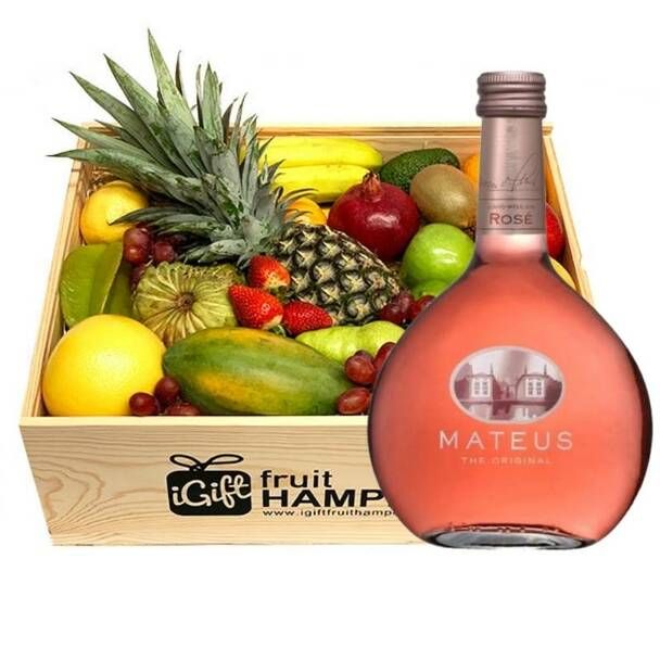 a bottle of fruit is sitting next to a box of wine and assorted fruits