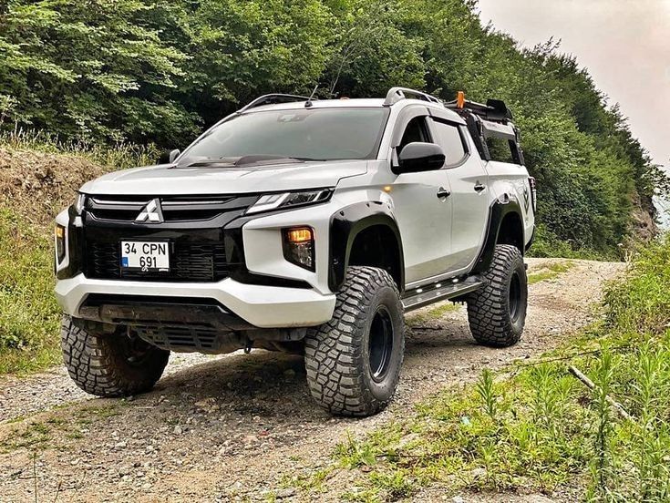 a white truck driving down a dirt road