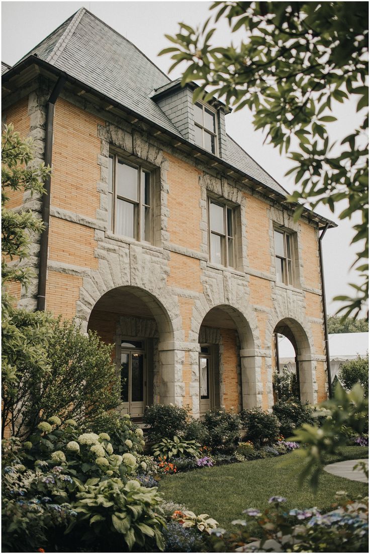 an old brick house with arched windows and landscaping