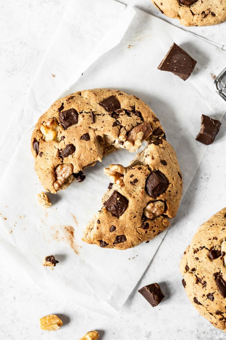 a chocolate chip cookie doughnut is cut in half and placed on a piece of parchment paper