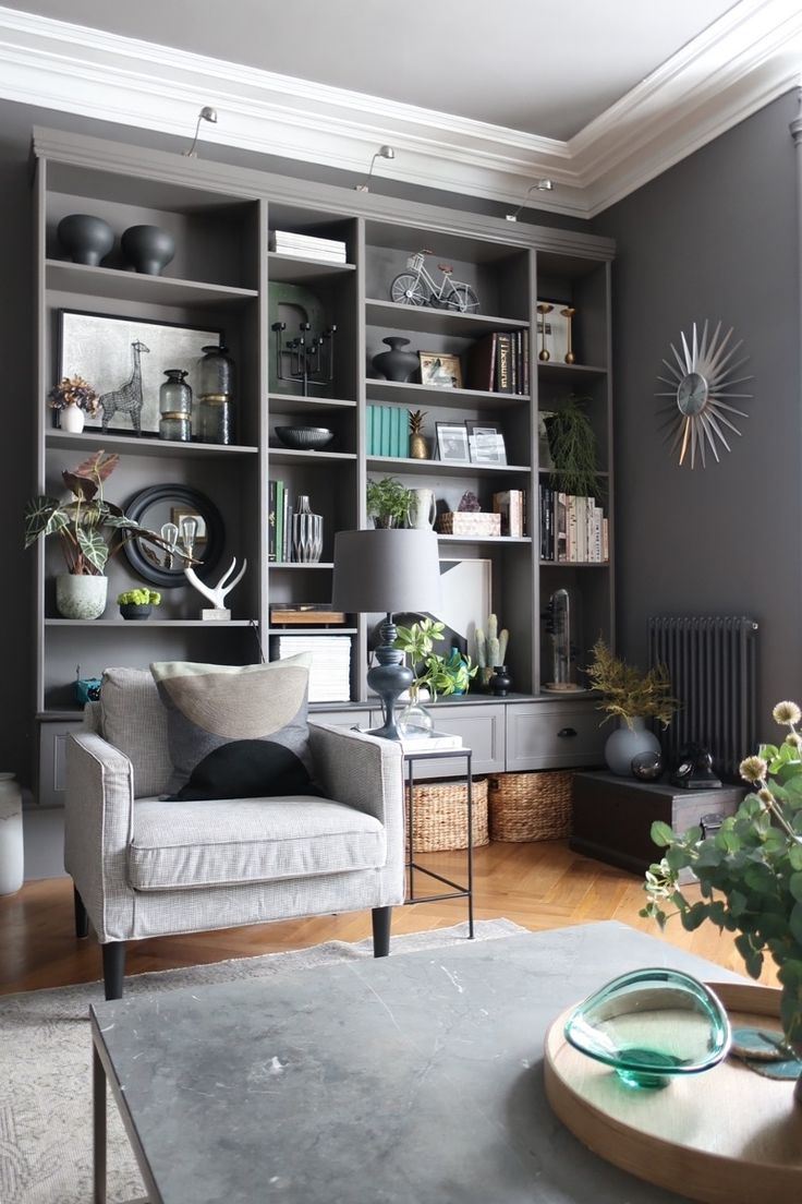 a living room filled with lots of furniture and shelves full of plants on top of them